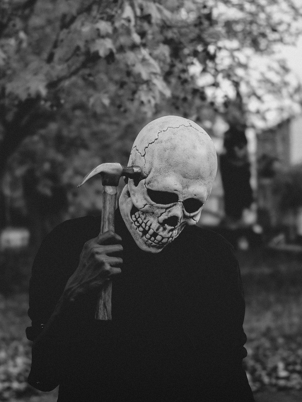 un uomo in una maschera da scheletro che tiene in mano un martello