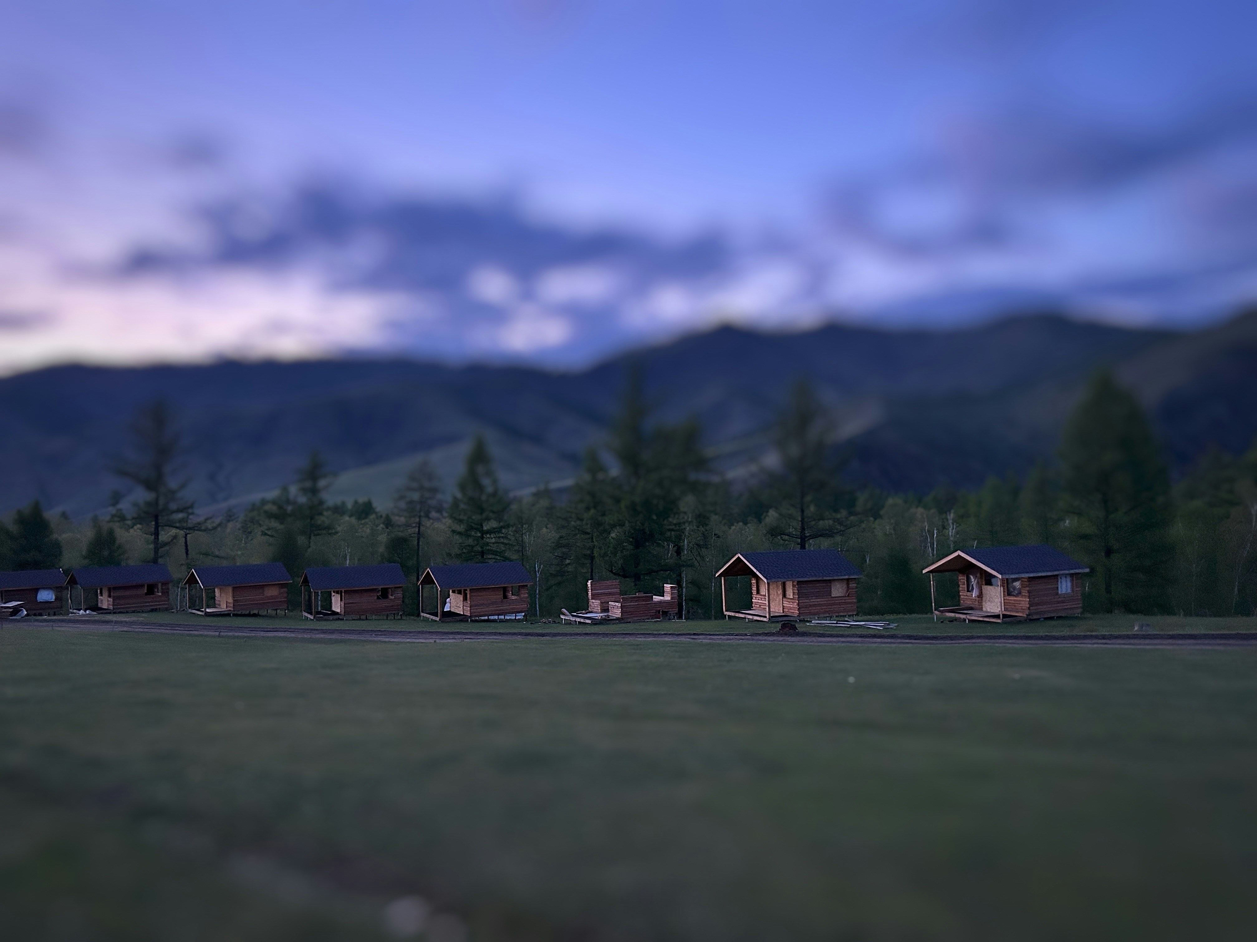 a blurry photo of a row of cabins in a field