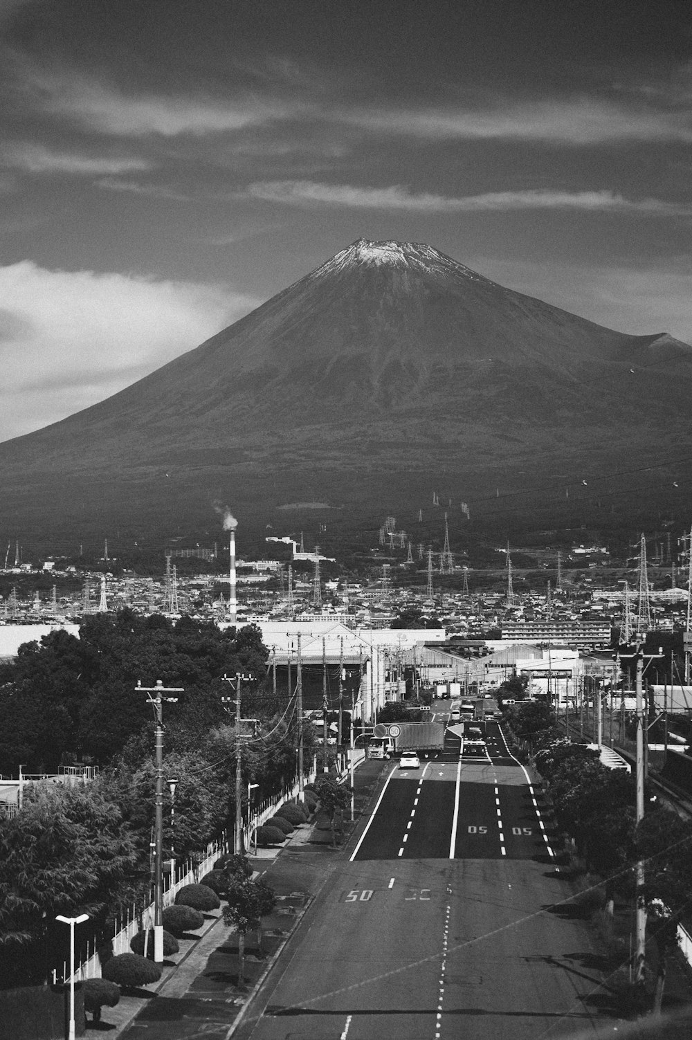 a black and white photo of a city with a mountain in the background