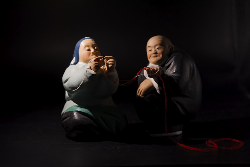 un paio di figurine sedute una accanto all'altra