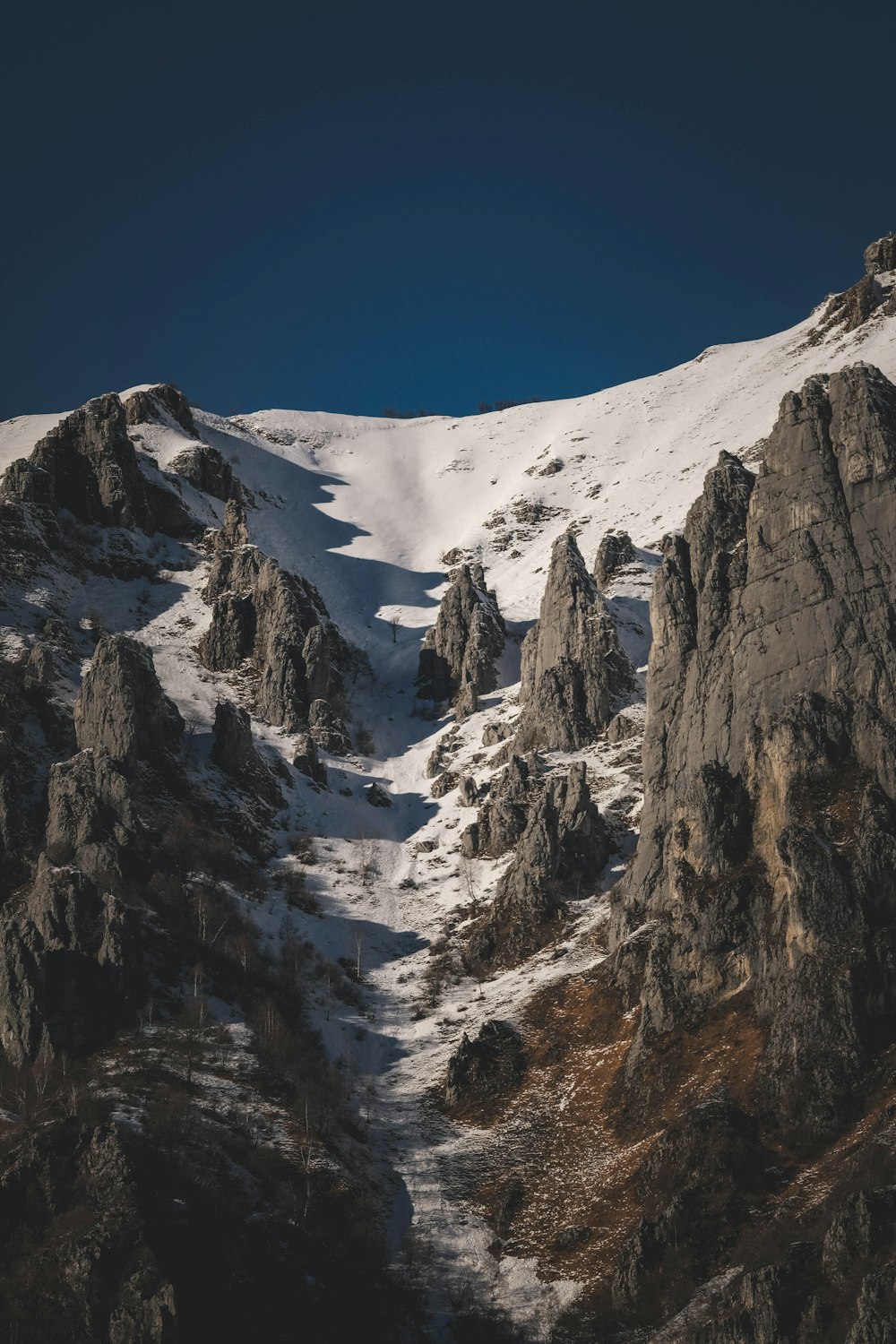 a snow covered mountain with rocks and grass