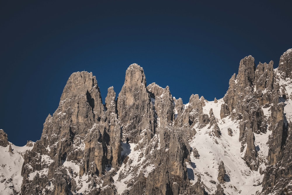 a very tall mountain covered in snow under a blue sky