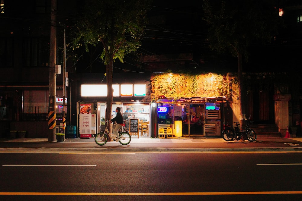 a person riding a bike down a street at night