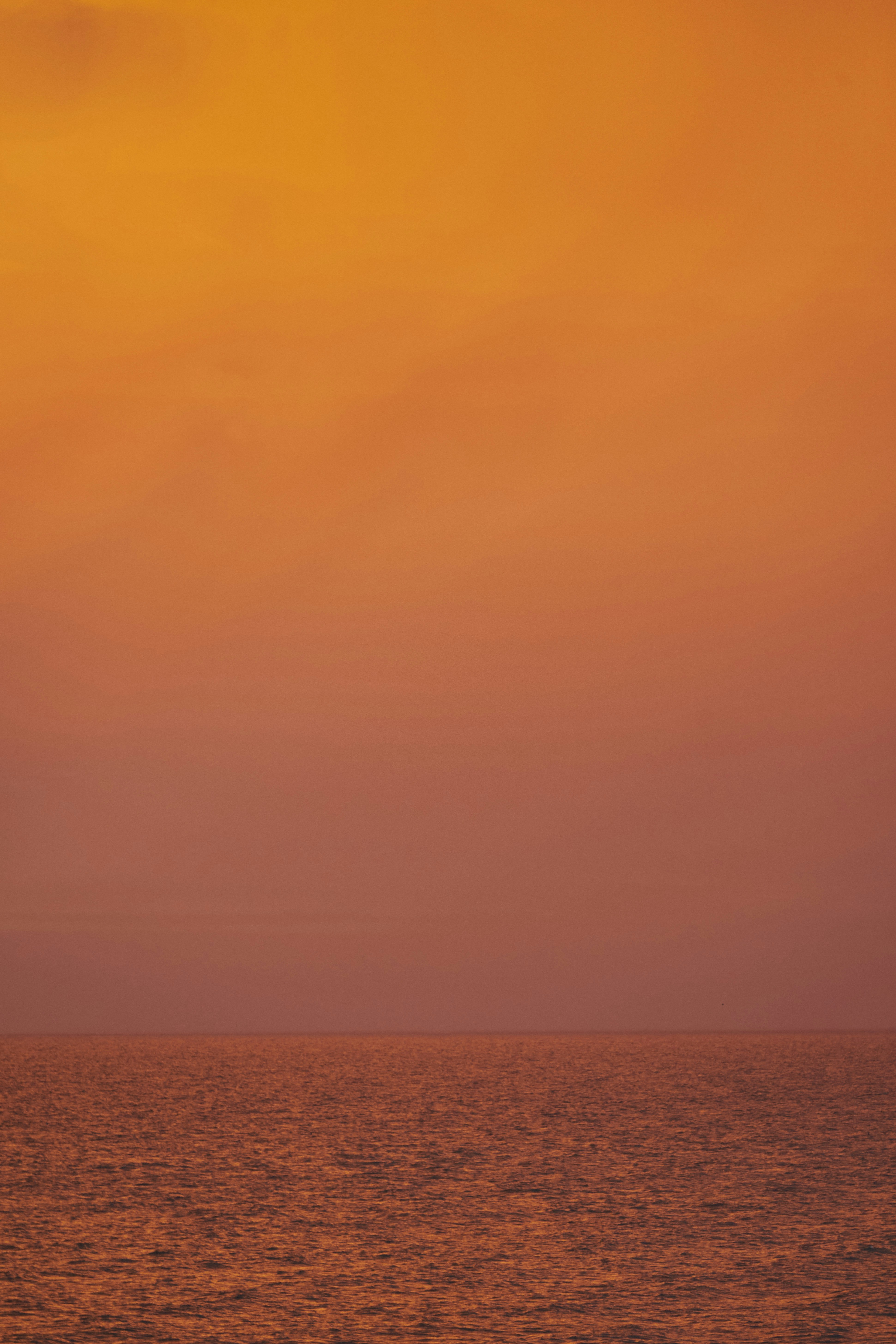 an orange sky over the ocean at sunset