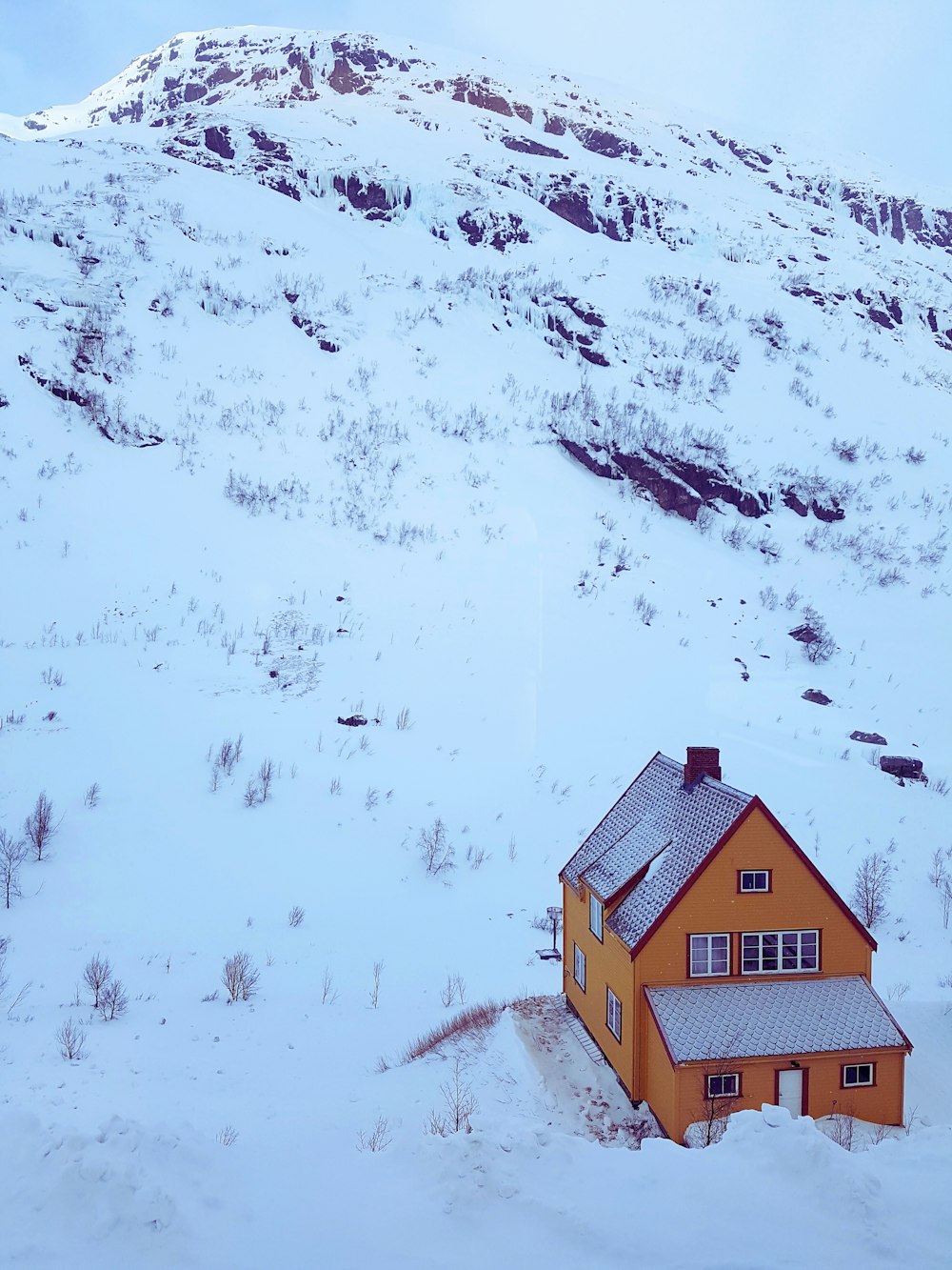 uma casa no meio de uma montanha nevada