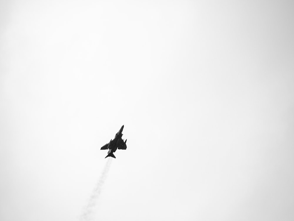 a fighter jet flying through a cloudy sky