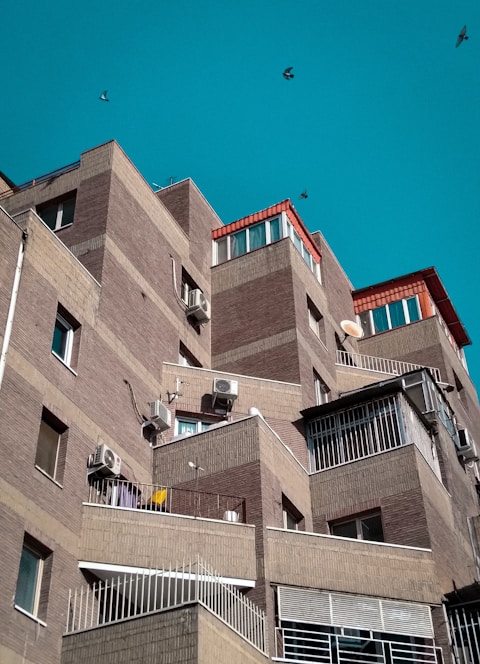 View of modern apartments with balconies overlooking the historic San Lázaro aqueduct in Mérida