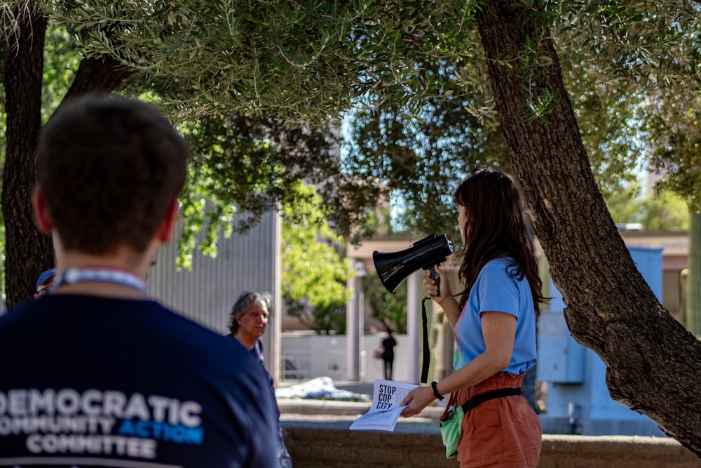 a woman holding a megaphone standing next to a man