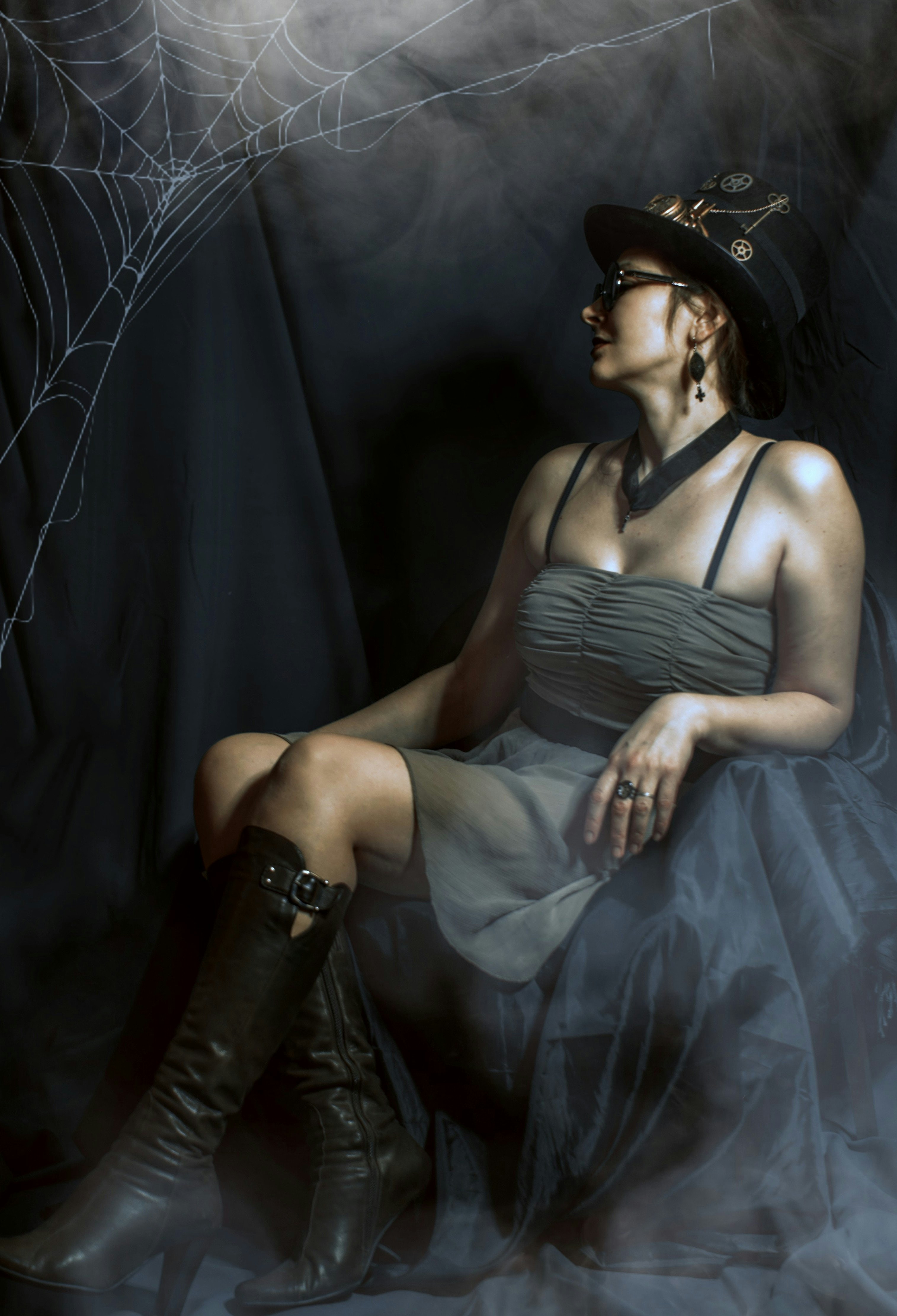 a woman in a dress and hat sitting on a chair