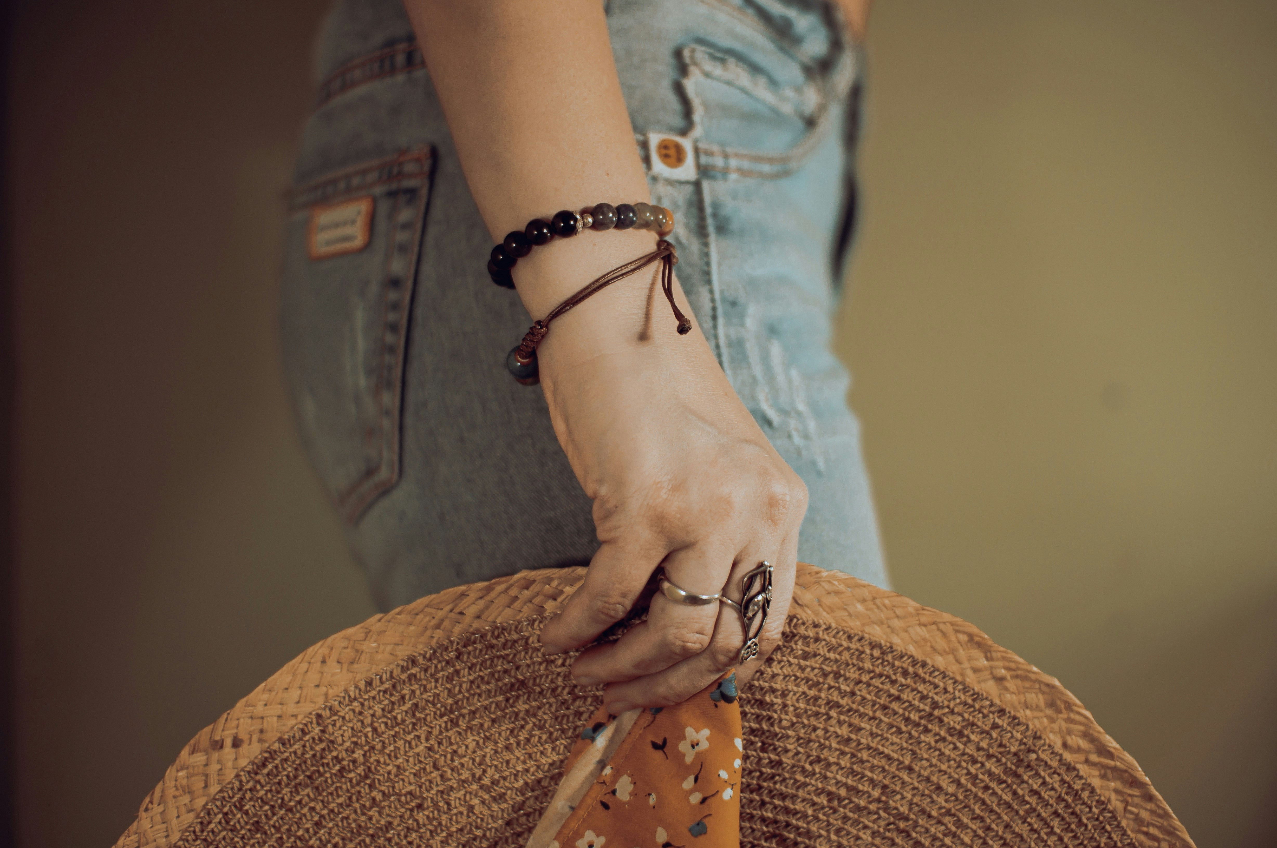 a woman's hand holding a straw hat