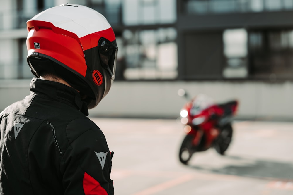 a person wearing a helmet standing next to a motorcycle