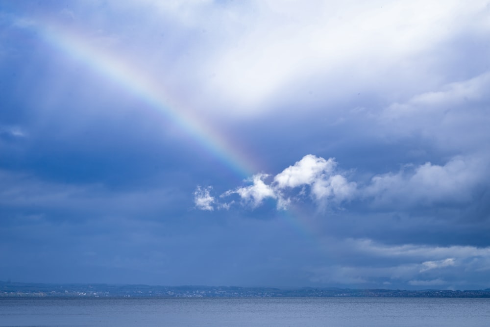 a rainbow in the sky over a body of water