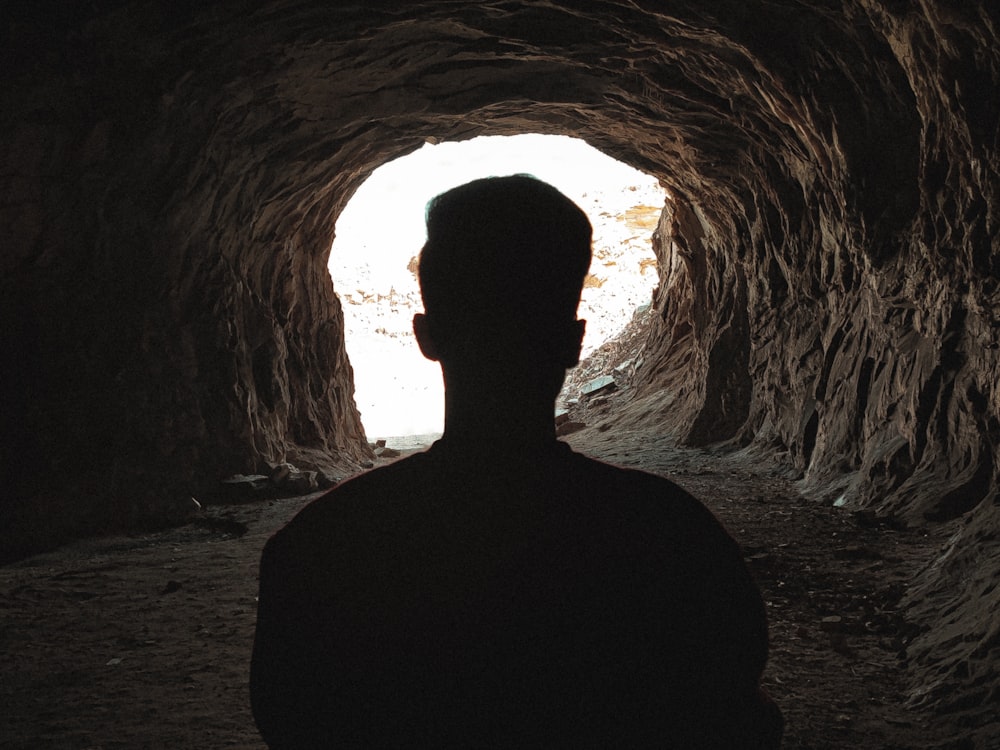 a man is standing in a dark cave