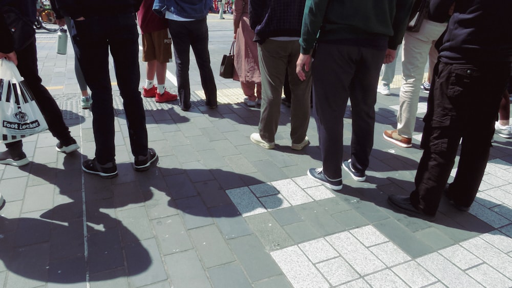 a group of people standing on a sidewalk