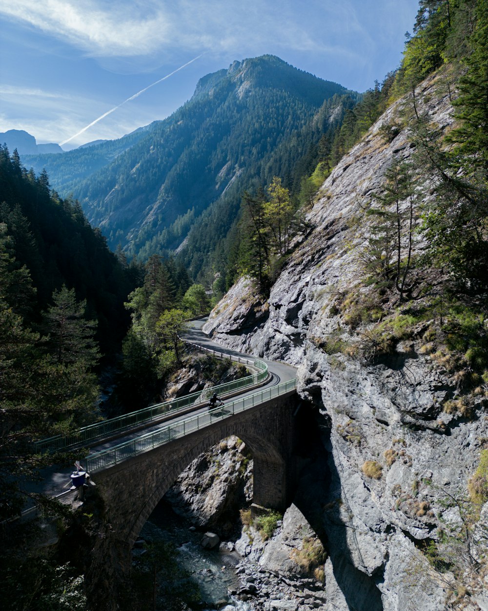 a bridge over a river with a mountain in the background