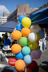 Children enjoying a colorful outdoor event with balloons and games.