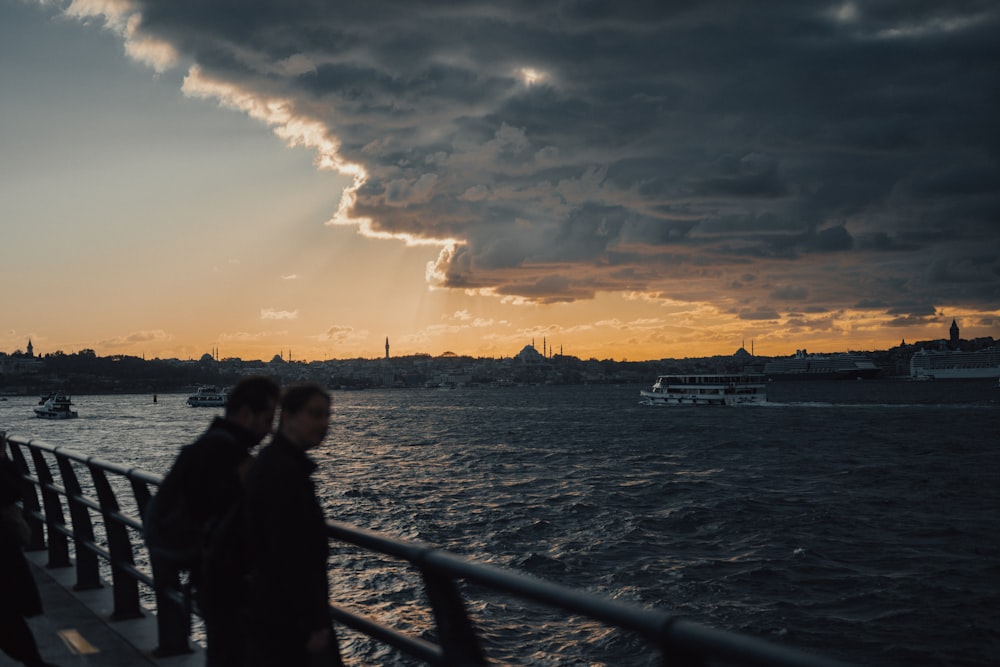 a couple of people that are standing on a pier