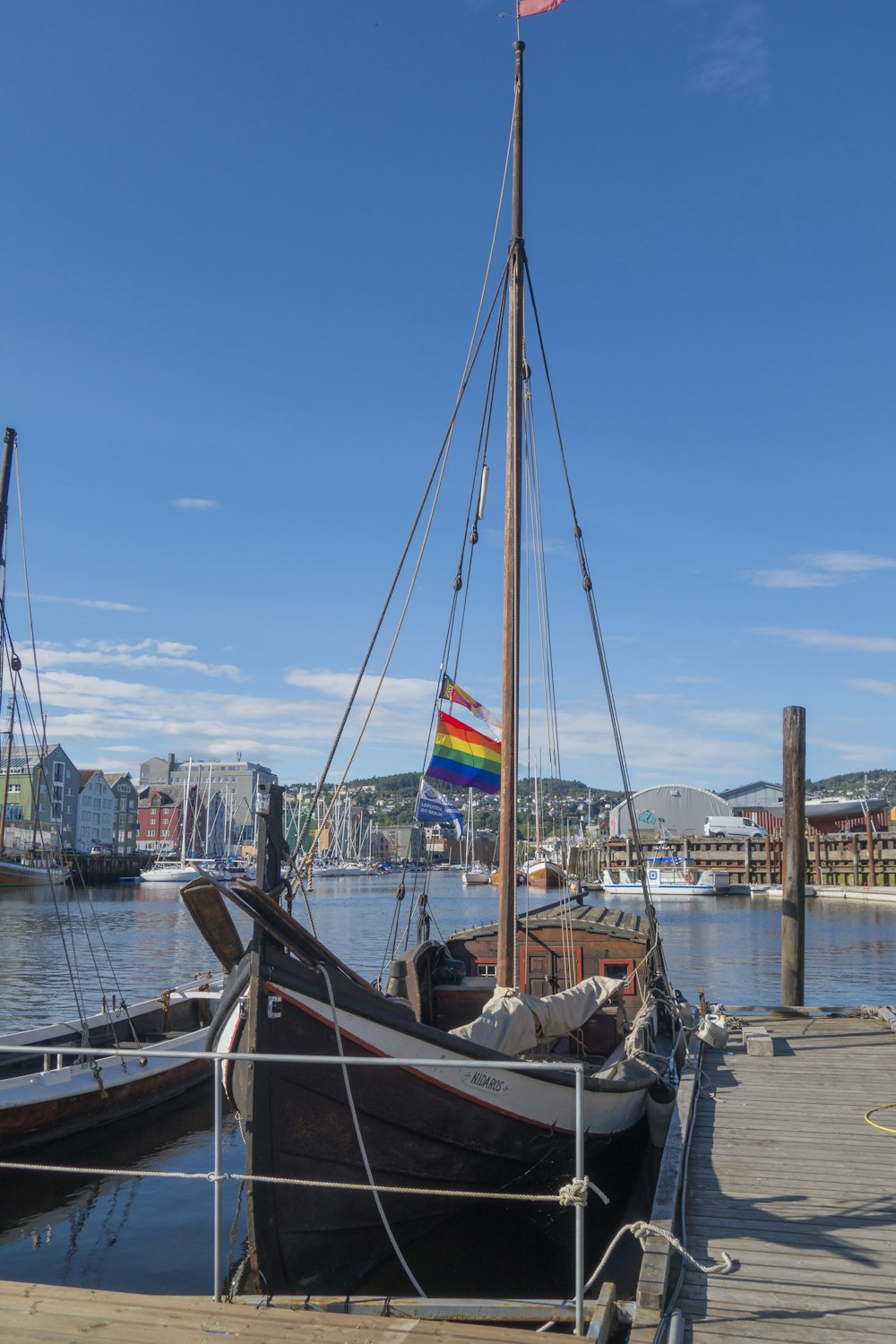 a boat docked at a dock with a rainbow flag