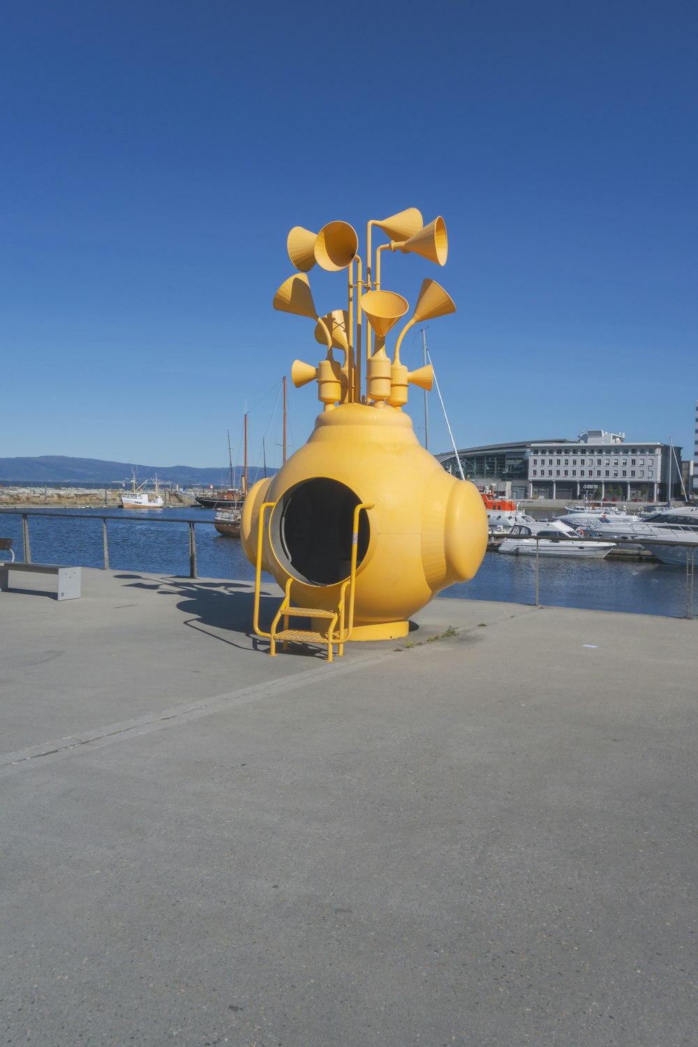 a yellow submarine shaped object sitting on top of a cement ground