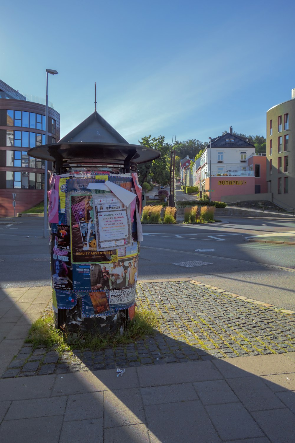 a newspaper dispenser sitting on the side of a road