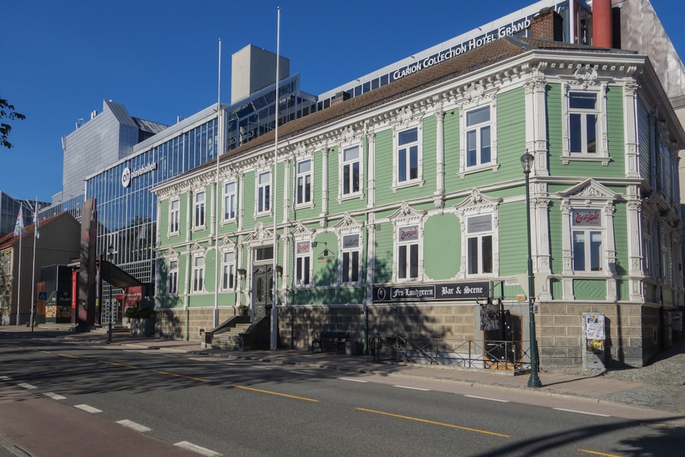 a large green building sitting on the side of a road