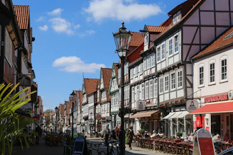 Historic half-timbered houses lining a charming street in Troyes under a bright blue sky.