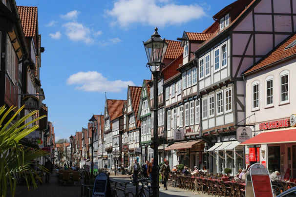 Historic half-timbered houses lining a charming street in Troyes under a bright blue sky.