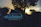 A happy couple enjoying a sunset view from the roof of their camper van parked in nature.