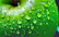 Close-up of a green apple-flavored liquid supplement bottle with droplets on it.
