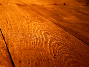 Close-up of a handcrafted walnut cutting board with rich grain patterns under warm light.