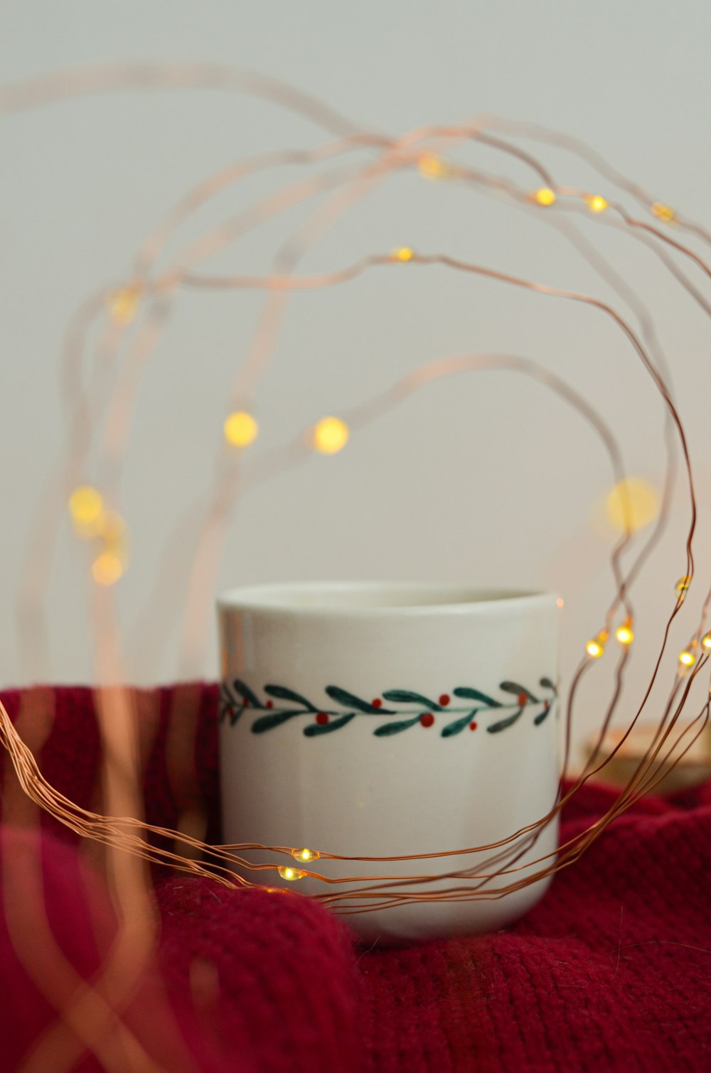 a white coffee cup sitting on top of a red blanket