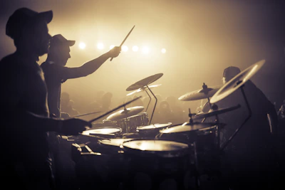 A wide shot of the band rocking out on stage with an energetic crowd in front.