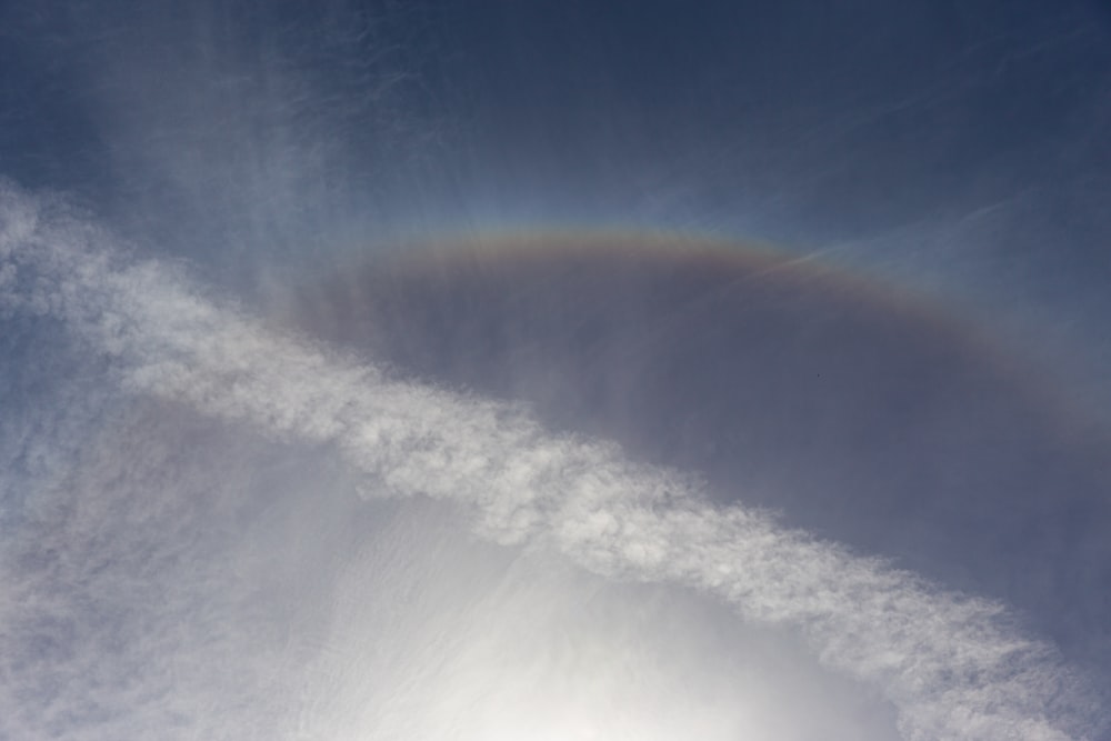 a rainbow is seen in the sky above a cloud