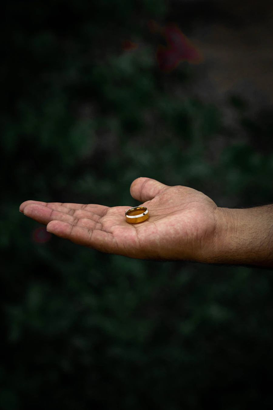 Mão estendida exibindo anel sinete com banho de ouro.