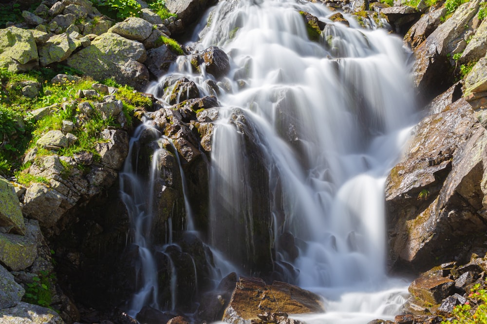 a small waterfall in the middle of a forest