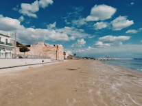 a sandy beach next to a body of water