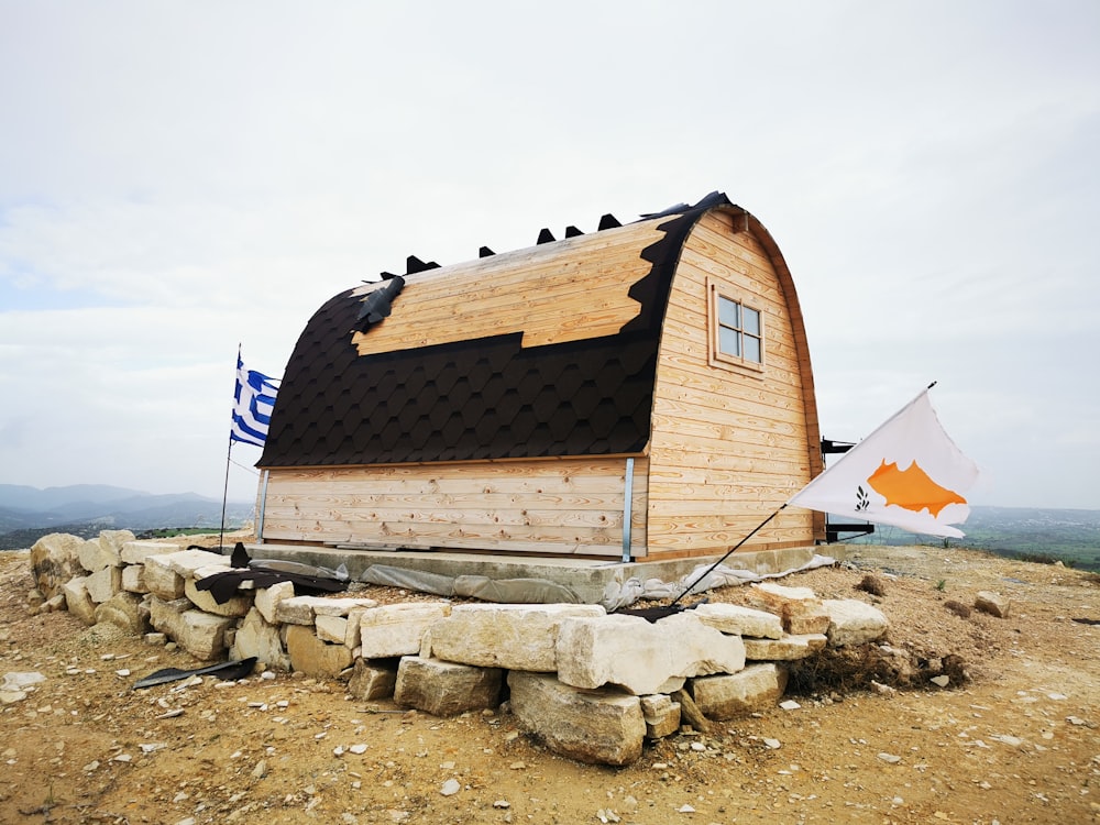 a wooden structure with a black roof on top of a hill