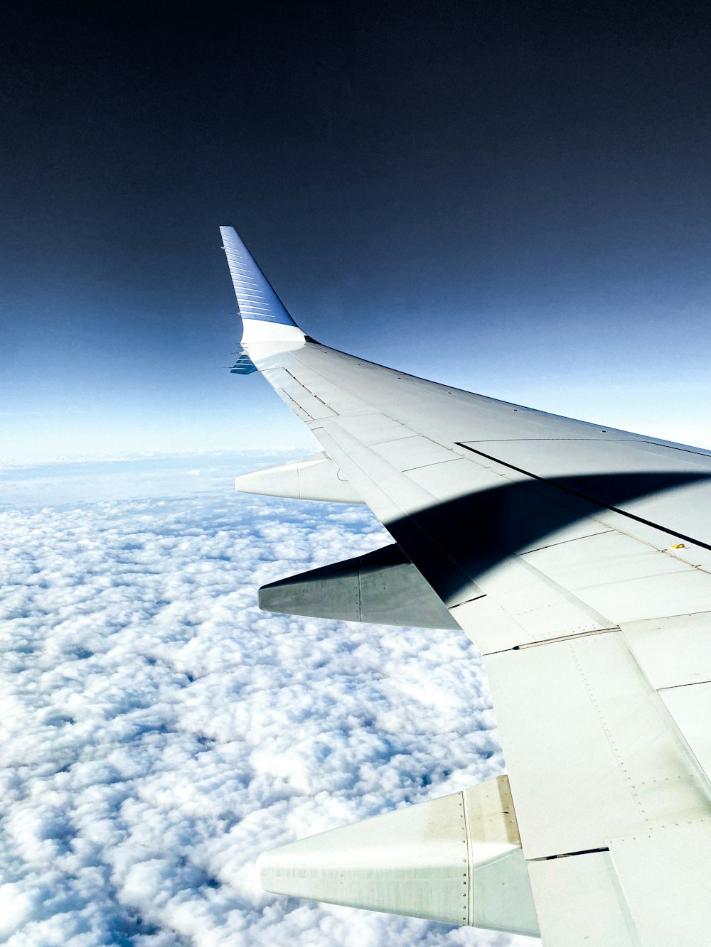 the wing of an airplane flying above the clouds