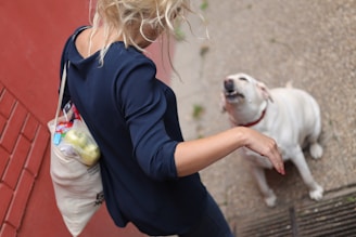 A smiling customer holding a bag of pet food outside the aupagro store on a sunny day.