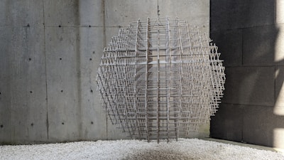 Sculpture made of intertwined metal rods in a modern gallery space.