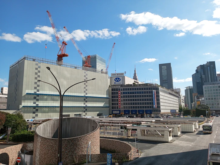 A vibrant urban transformation site in progress with cranes and workers under a clear sky.