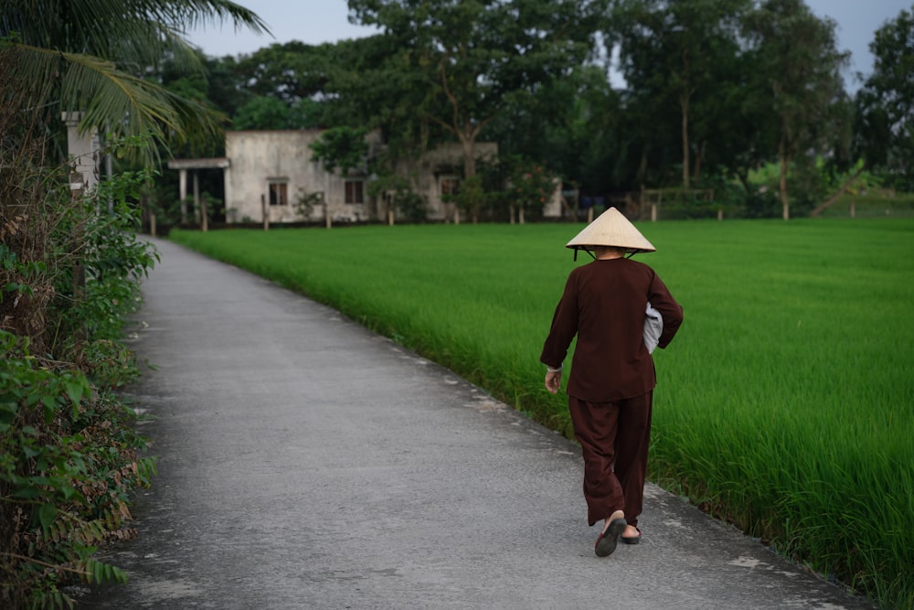 a person walking down a path with a hat on