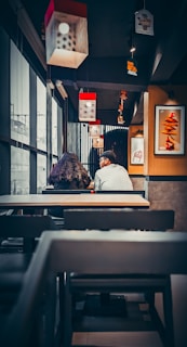A cozy café scene where two people are meeting for the first time, smiling warmly.
