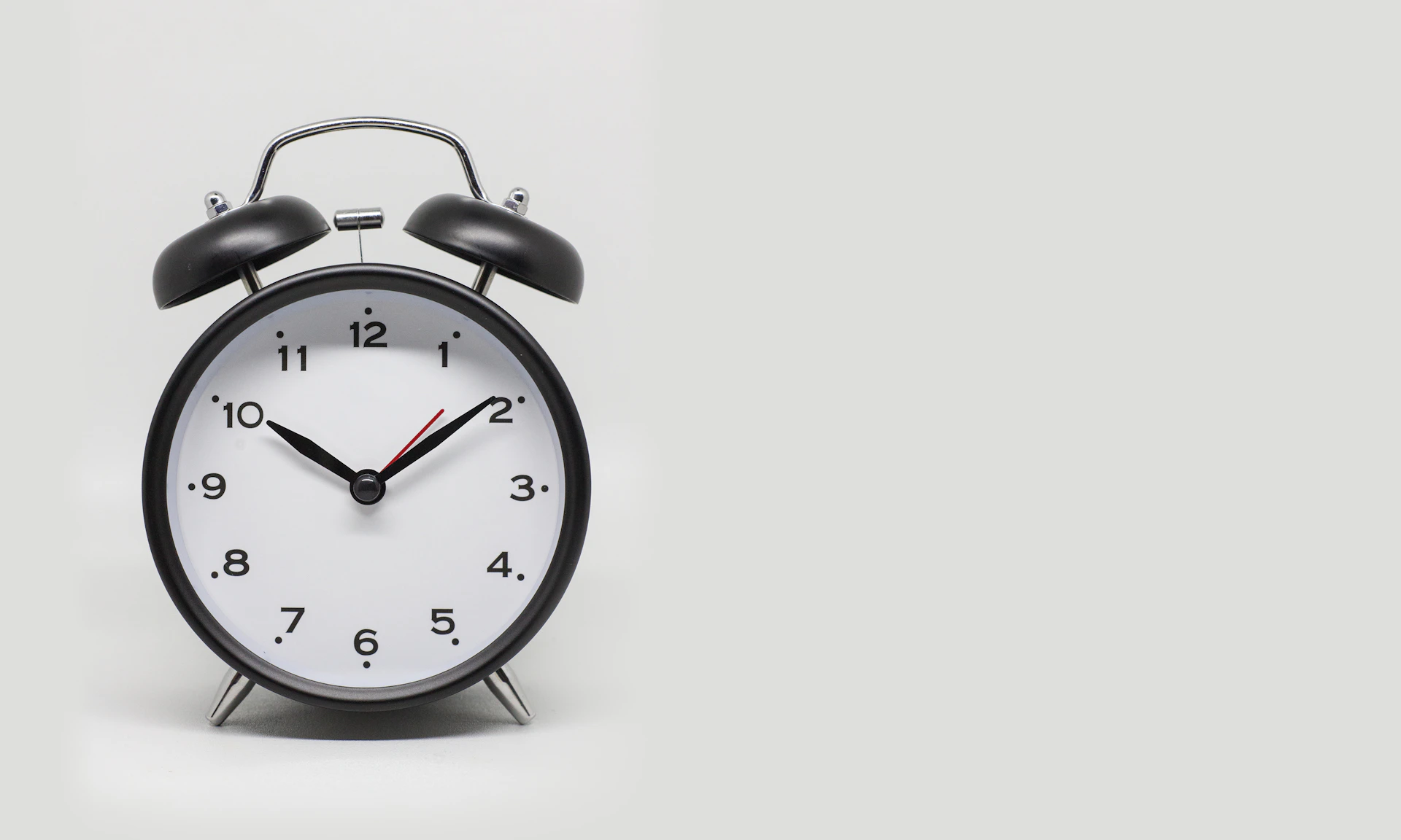 a black and white alarm clock on a white background