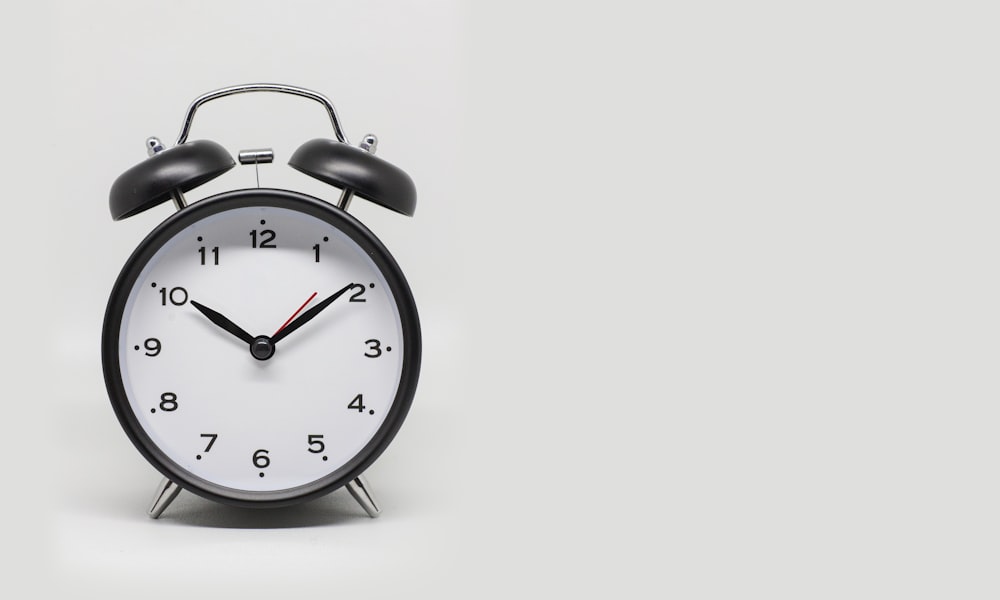 a black and white alarm clock on a white background