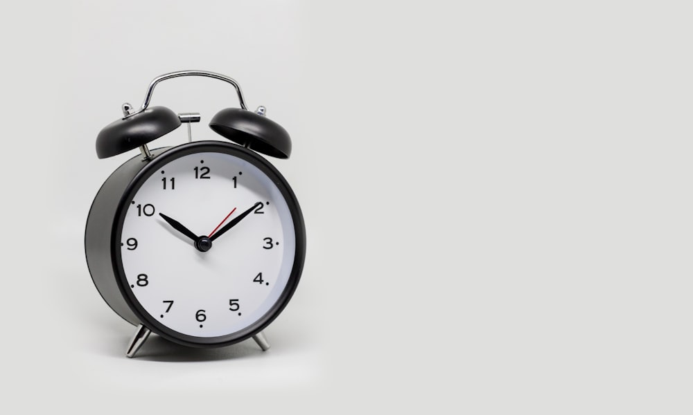 a black and white alarm clock on a white background