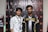 Two individuals stand in front of a backdrop with logos and text, dressed in casual clothing and sporting lanyards with badges. The individual on the left wears a patterned shirt, while the one on the right wears a shirt with the words 'Pathan Esports'.