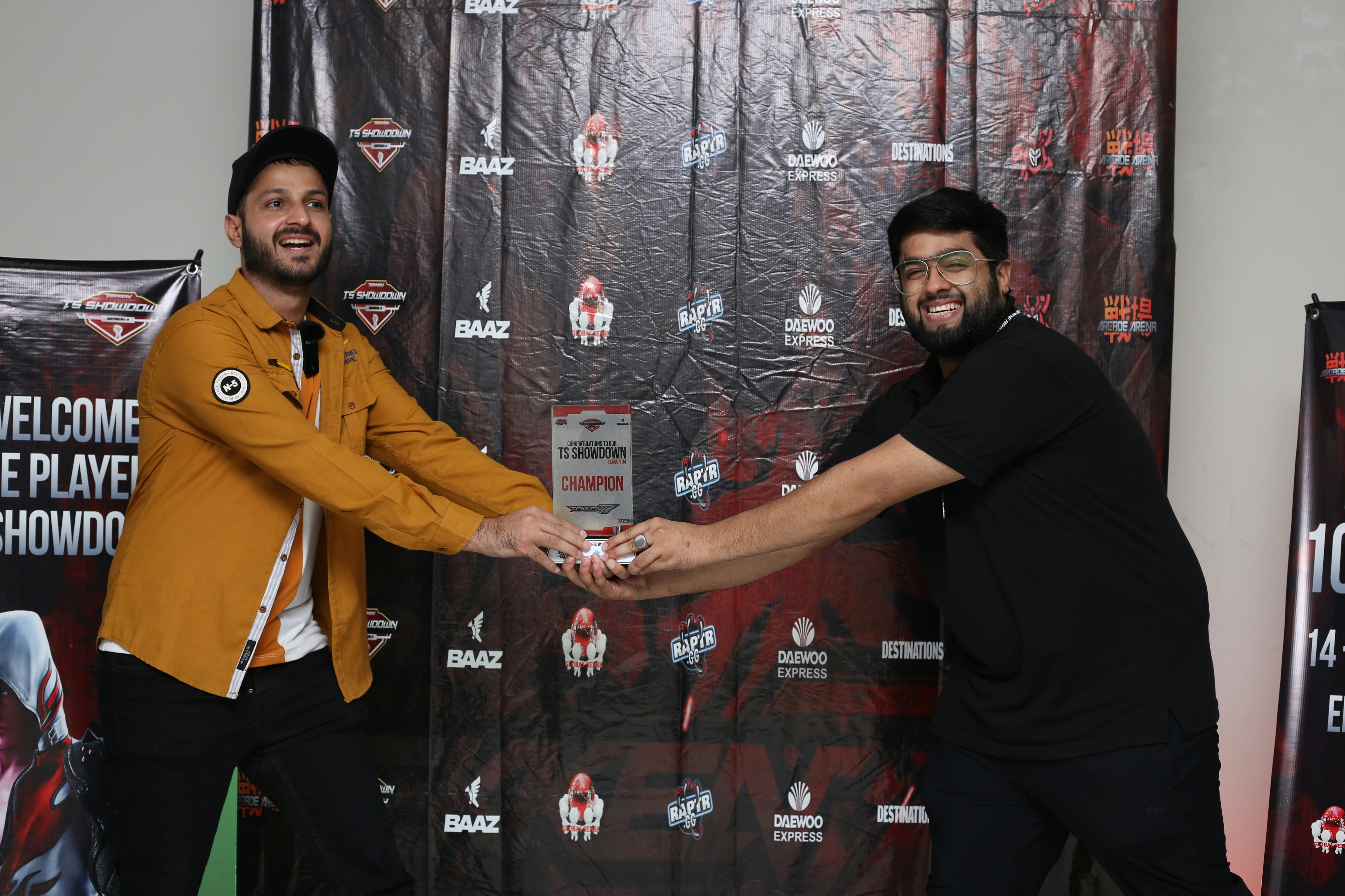 two men shaking hands in front of a backdrop