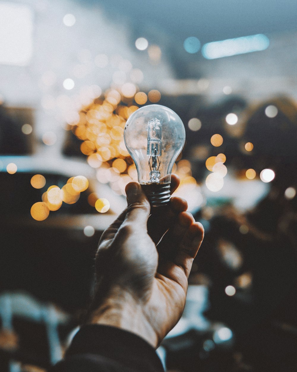 a person holding a light bulb in their hand