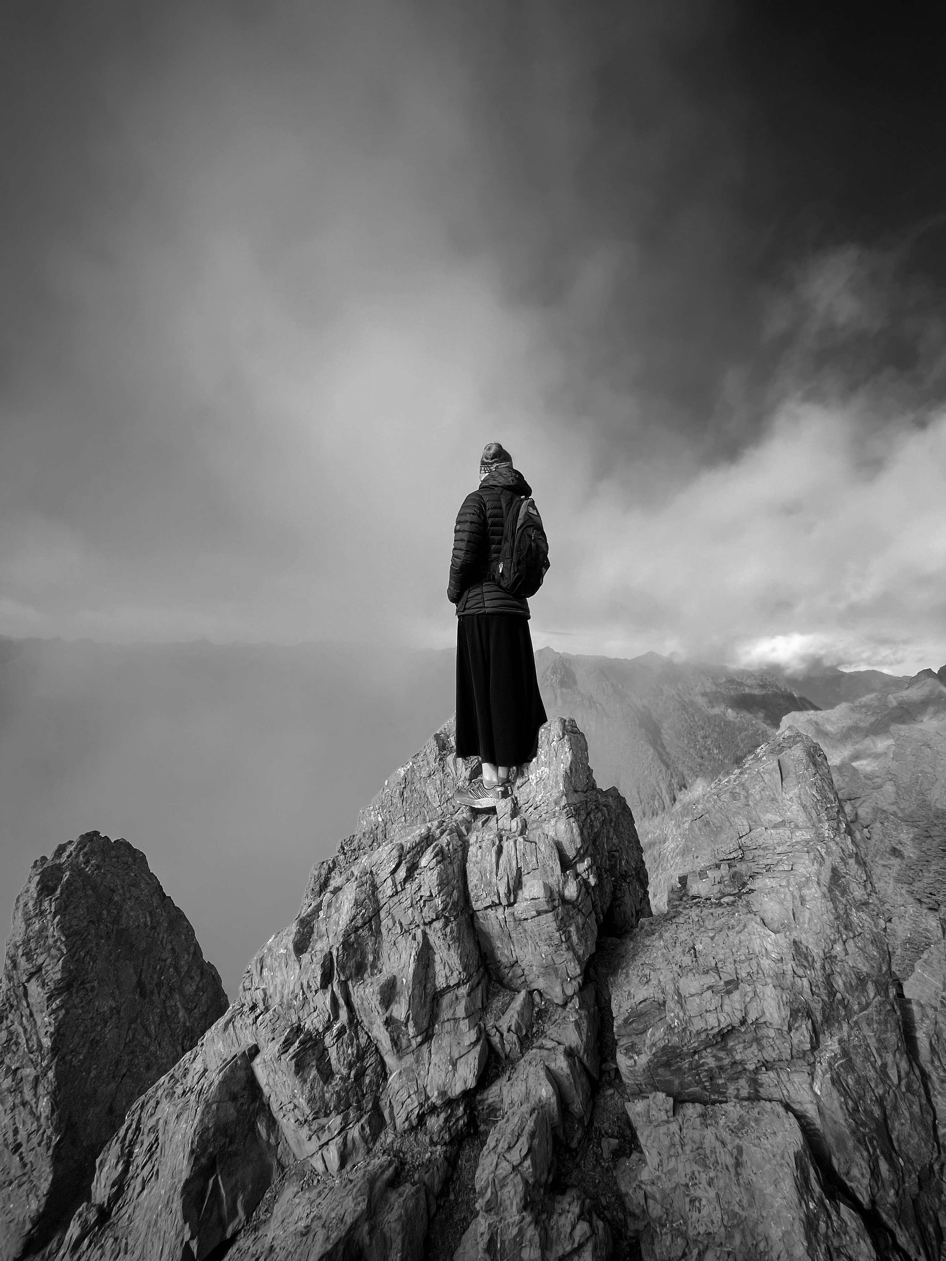 una persona in piedi sulla cima di una montagna rocciosa